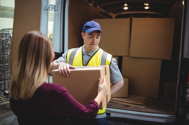 delivery driver handing parcel customer outside van warehouse 107420 13756